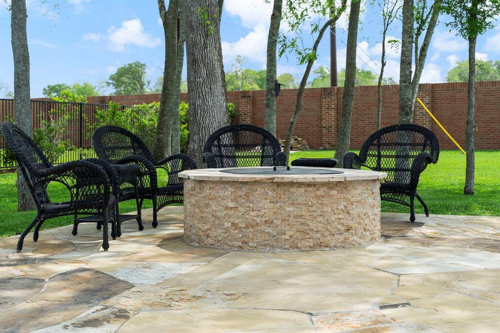 Cozy fire pit area nestled beneath mature trees—perfect for gathering with friends and family under the stars.