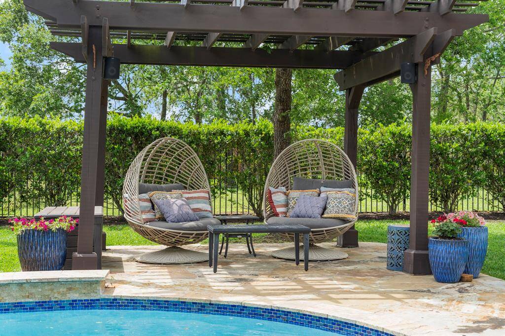 Relax in style beneath a custom pergola featuring serene views of the backyard oasis — the perfect spot for morning coffee or evening wine.
