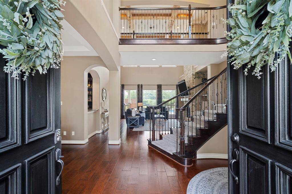Step inside to soaring ceilings, rich wood floors, and a sweeping staircase that sets a grand tone that perfectly blends elegance and warmth from the moment you enter.