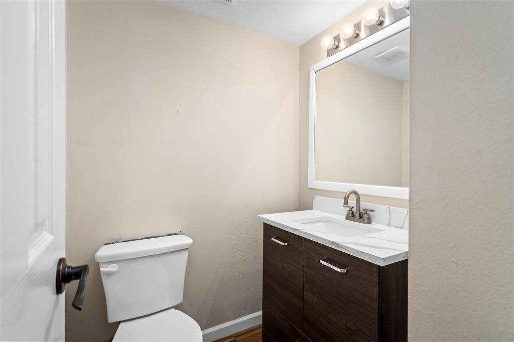 Your modern half bath includes a sleek vanity with quartz countertop and a large mirror. The neutral color palette and contemporary lighting provide a clean, fresh look.