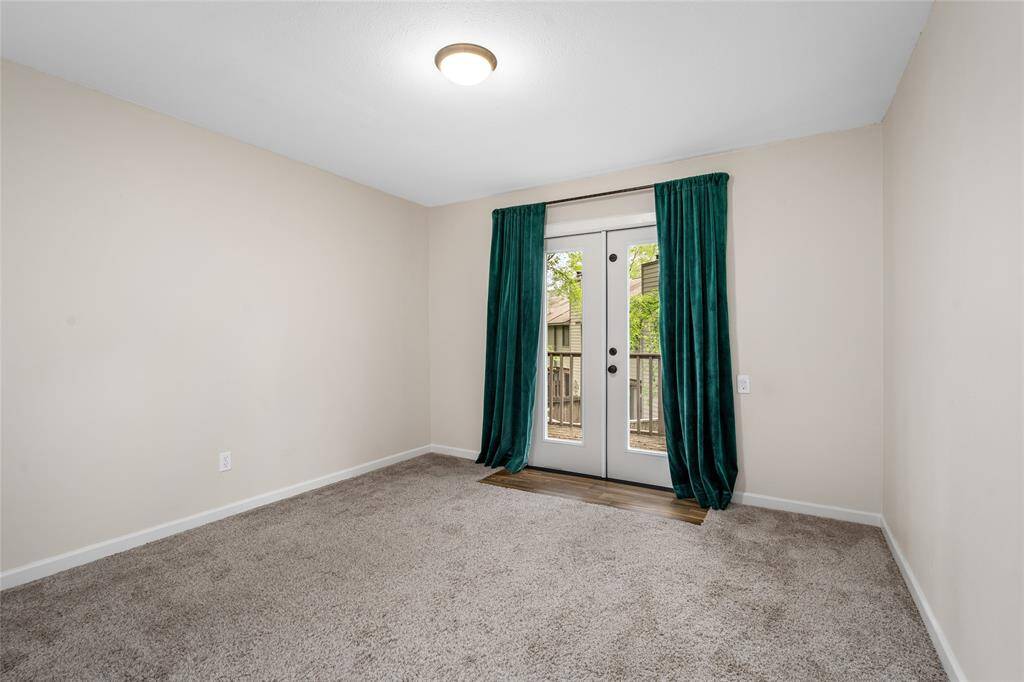 This room features neutral walls with cozy carpeting and French doors that open to a balcony.  Ideal for a bedroom or home office.