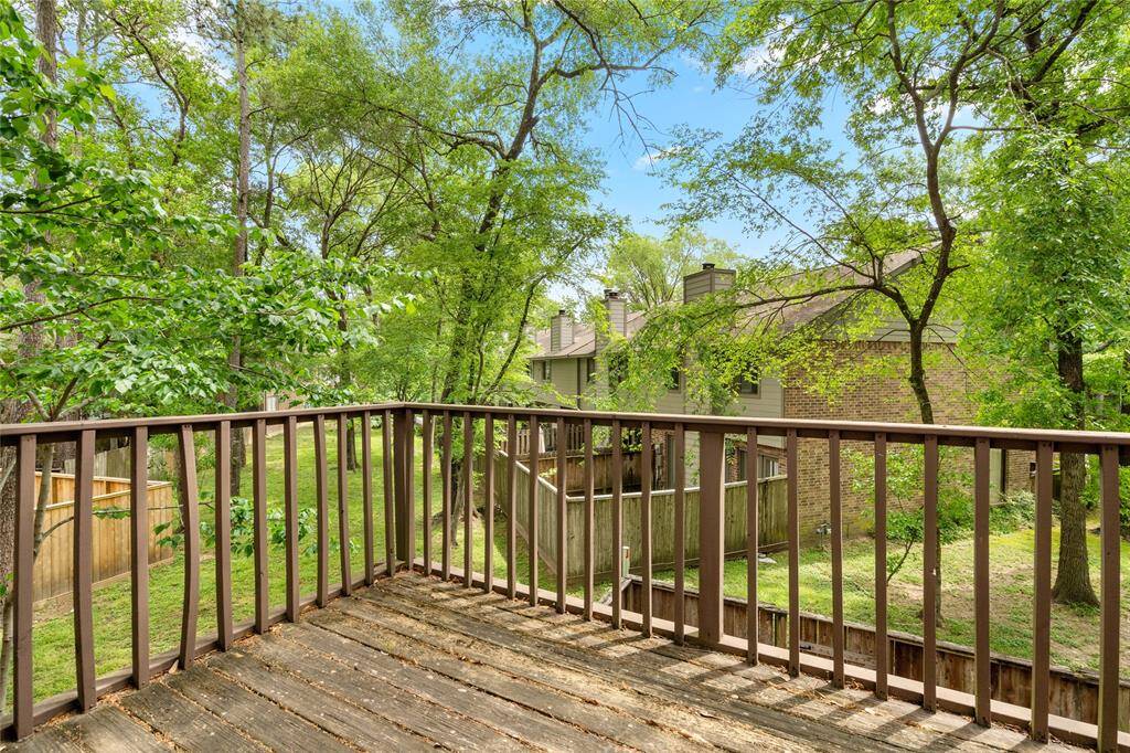 Your private balcony overlooks a lush green space with mature trees, an ideal spot for relaxation and enjoying nature.