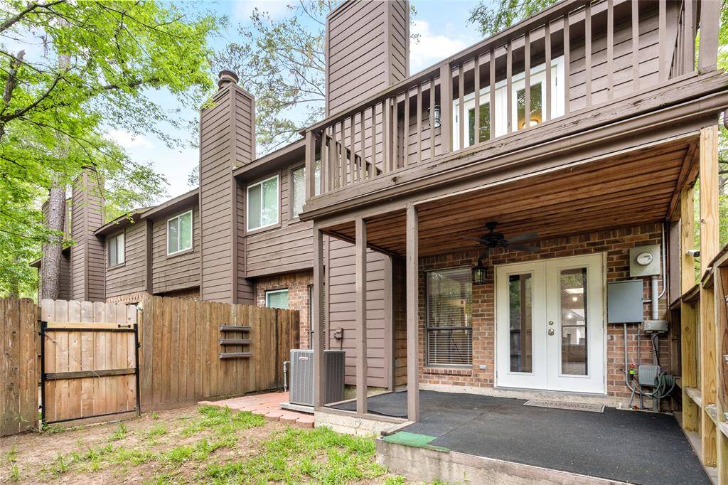 Your charming two-story townhouse includes an upper balcony, brick accents, and large windows, providing a cozy outdoor space. The patio has plenty of room for a grill and covered seating area.
