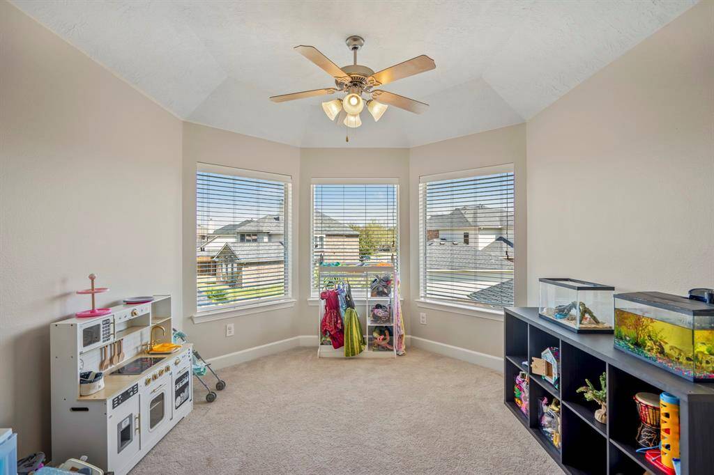 This game room extends into a bright nook with panoramic windows, ideal for a play area, reading corner, or additional seating with natural light.
