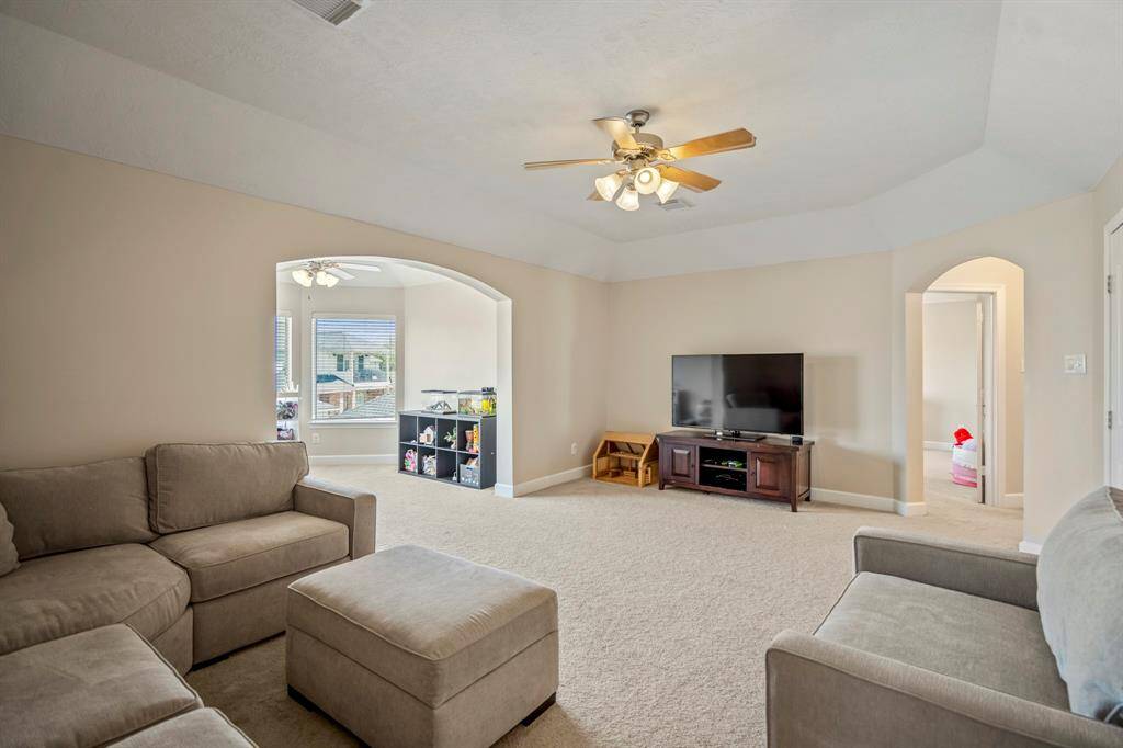 A versatile upstairs retreat with soaring ceilings, neutral tones, and an open layout, perfect for entertainment, relaxation, or a home theater.
