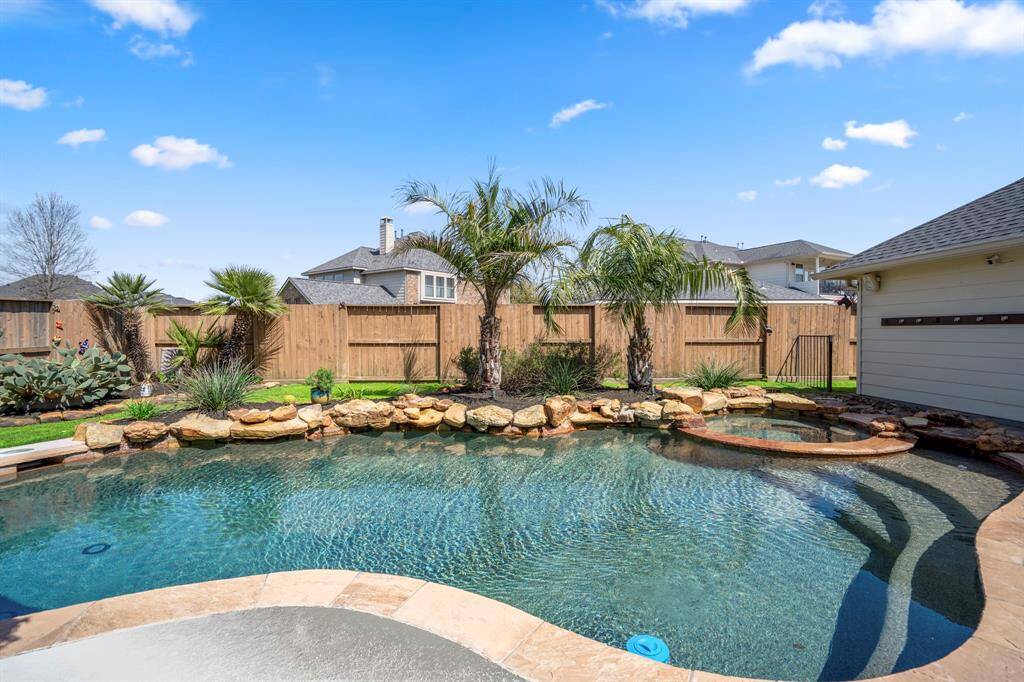 Private backyard paradise—fully fenced yard, mature palm trees, and beautifully manicured gardens for the ultimate tranquil escape.