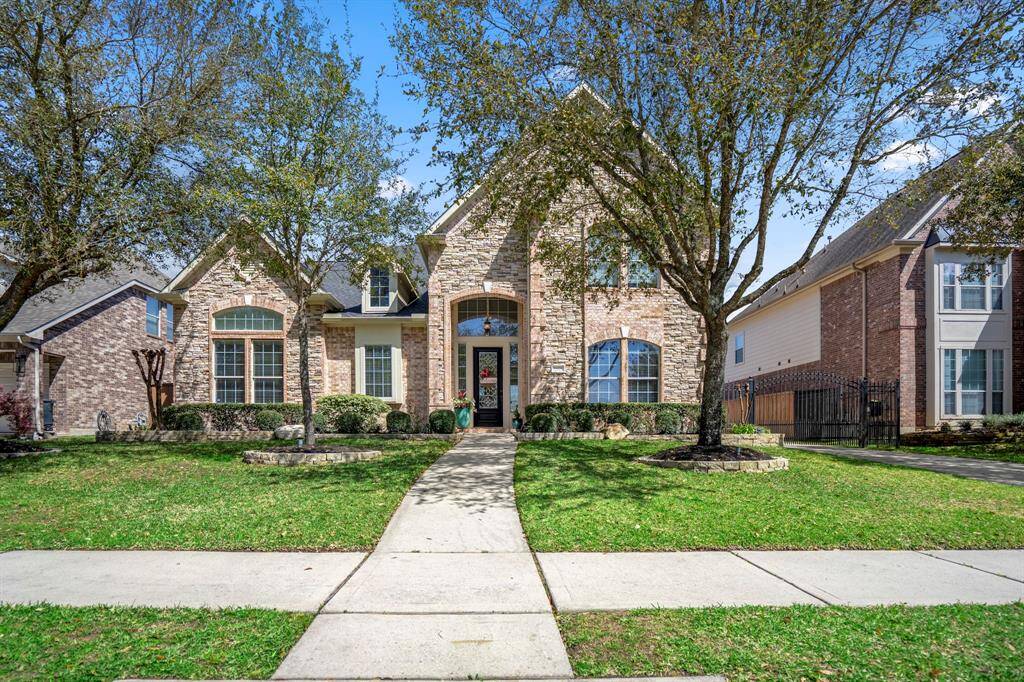 This elegant 5-bedroom, 4-bath home boasts stunning curb appeal with stone and brick elevation, mature trees, and lush landscaping.