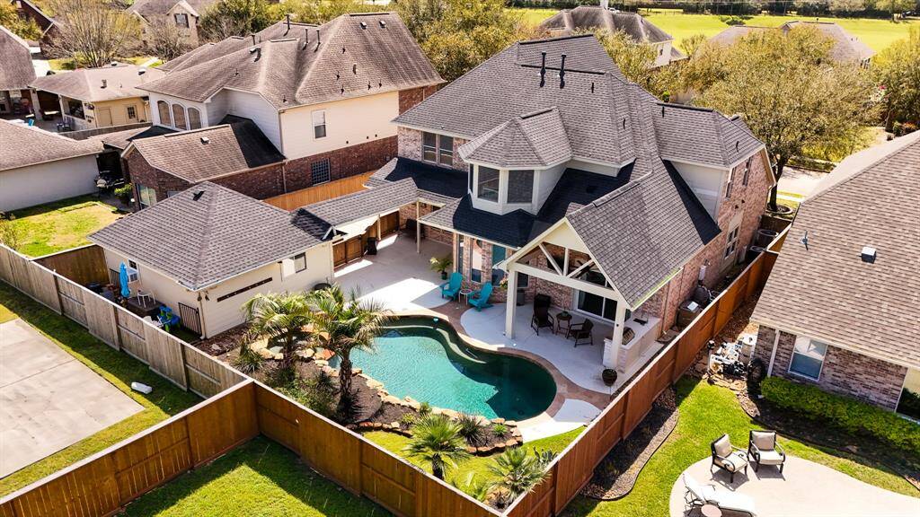 Designed for relaxation and entertainment, this resort-style backyard is a showstopper. A custom lagoon-style pool and spa with rock accents create a serene retreat. Lush tropical landscaping and a covered patio with a vaulted wood-paneled ceiling complete this private paradise.