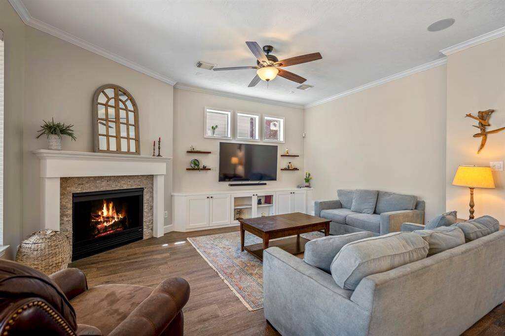Recessed lighting enhance the open feel, while custom shelving and a media wall create the perfect space for relaxation or hosting gatherings.