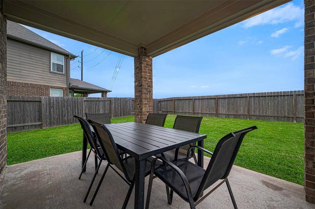 Out back, the covered patio sits perfectly at the rear of the home, offering shaded outdoor space ideal for gatherings or quiet evenings.