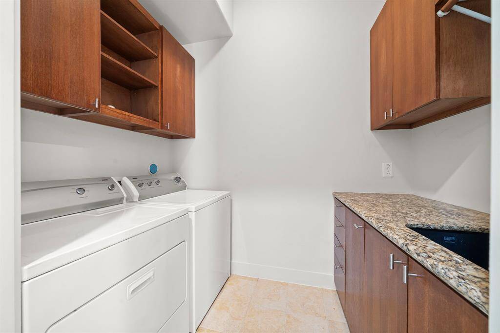 2nd Floor: Utility room with granite countertops, sink and custom hardwood cabinetry for organization