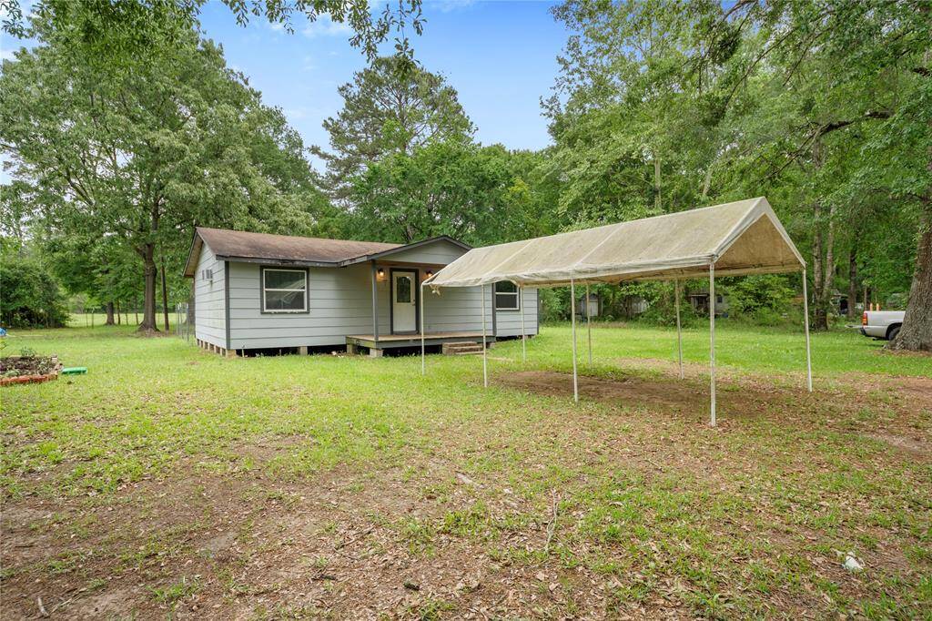 The property includes a versatile covered parking structure and lush front yard. A welcoming first impression and functional outdoor space await.