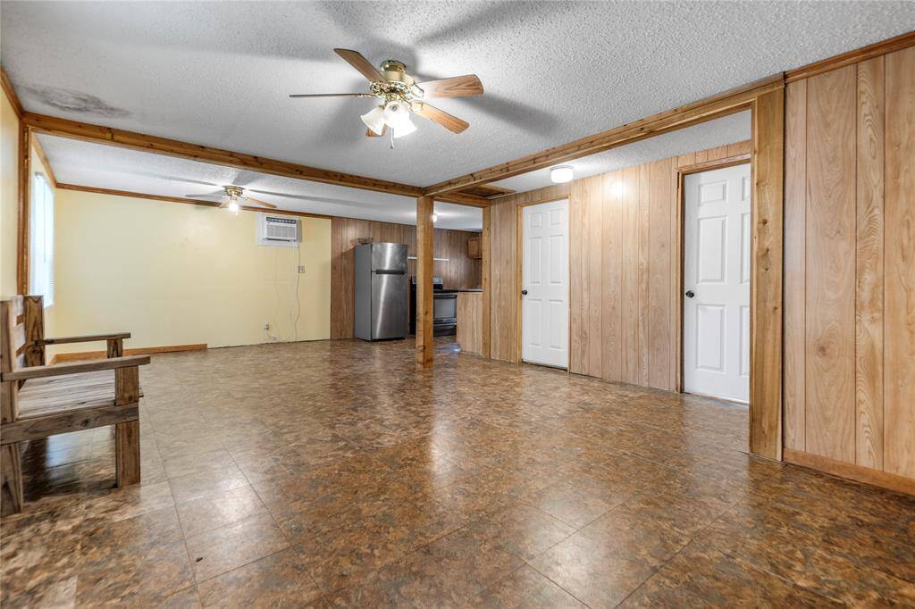A generous open-concept living area offers great bones and layout flexibility. Natural wood accents and ceiling fans add a cozy, rustic touch. The space is ready for creative updates to truly make it shine.