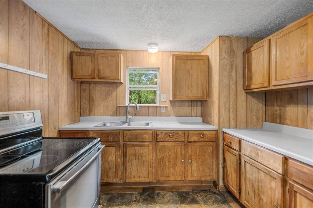 A well-structured kitchen with natural wood cabinets and wide countertops. Thoughtful updates here could create a high-impact transformation for modern living or resale appeal.