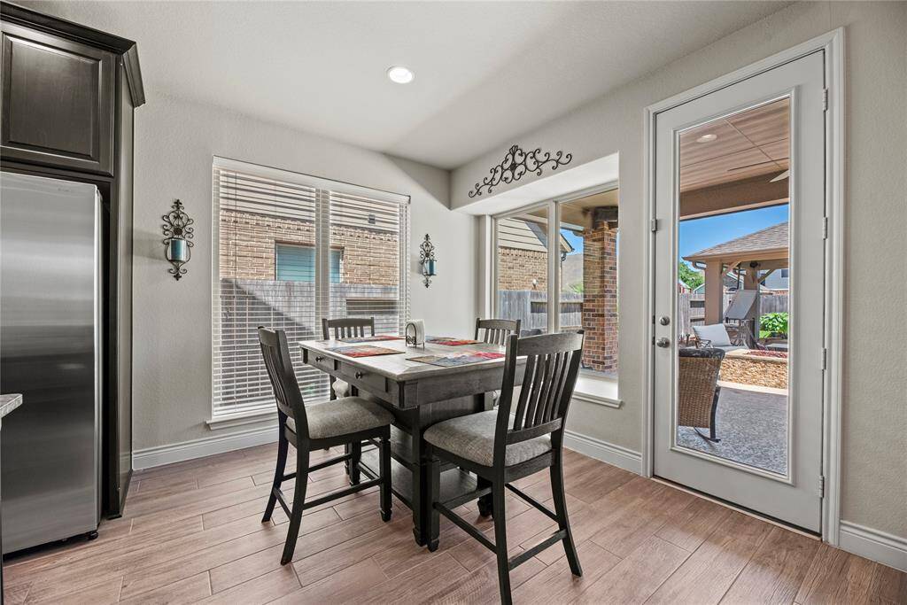 Start your day at this bright kitchen nook dining area featuring large windows and a door leading to an outdoor covered patio and fantastic back yard.