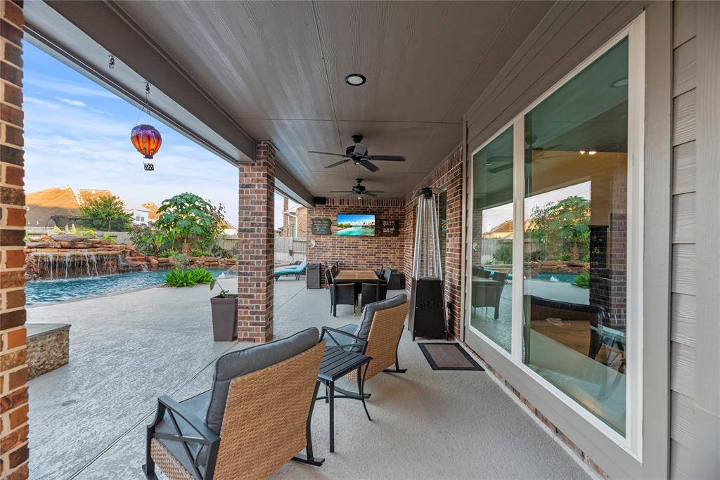 This photo showcases the spacious covered patio with plenty of room for seating! It overlooks the beautiful pool.