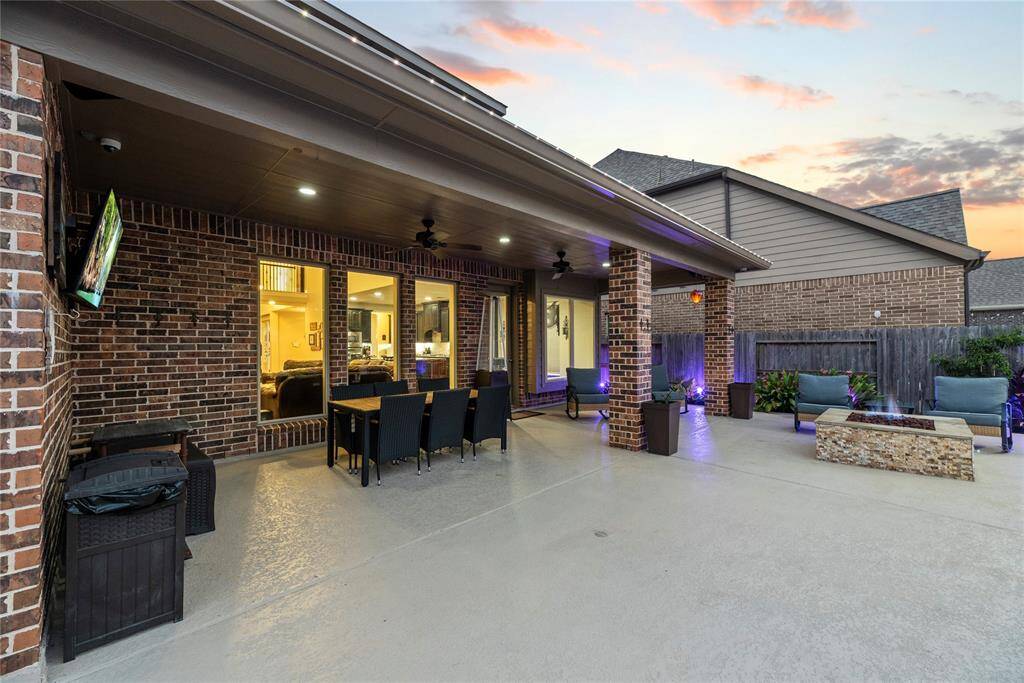 Another view of the back covered patio with a built in fire pit area.