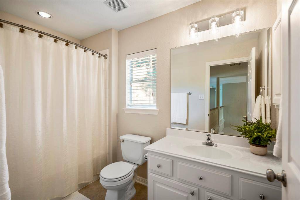 Located between the game room and the spacious bedroom, this upstairs full bath features a small window that fills the space with natural light. It's a well-appointed bath designed for convenience and comfort.