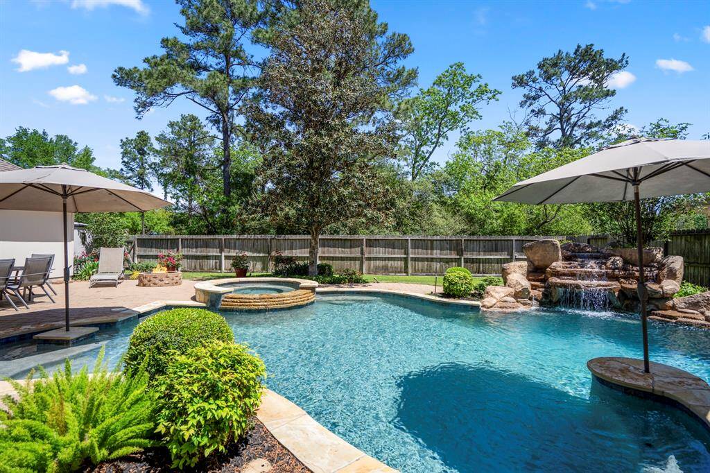 Take a closer look at the glistening waters of the pool, with its serene cascading waterfall inviting you to unwind. Imagine taking a refreshing plunge this summer, with the soothing sound of water flowing and the sun shining down—this backyard oasis is perfect for relaxation and fun.