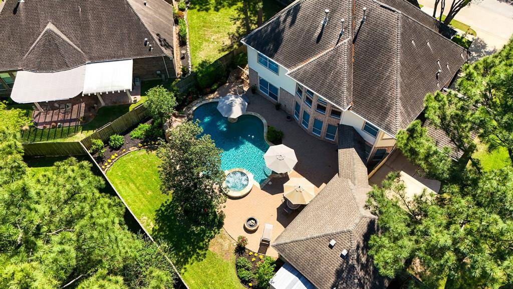 From this angle, you get a better look at the driveway, detached garage, and the covered parking area, all nestled under the shade of mature trees. This view offers a sense of privacy and tranquility, enhancing the home's appeal and functionality.