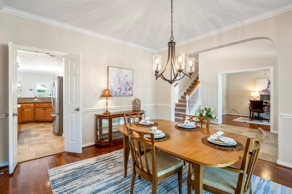 From the formal dining room, you can see through the double doors into the kitchen and breakfast area beyond. To the right, an arched opening leads into the foyer, with a clear view of the study through French doors. The staircase is just to the left of the study, offering a seamless flow between spaces.