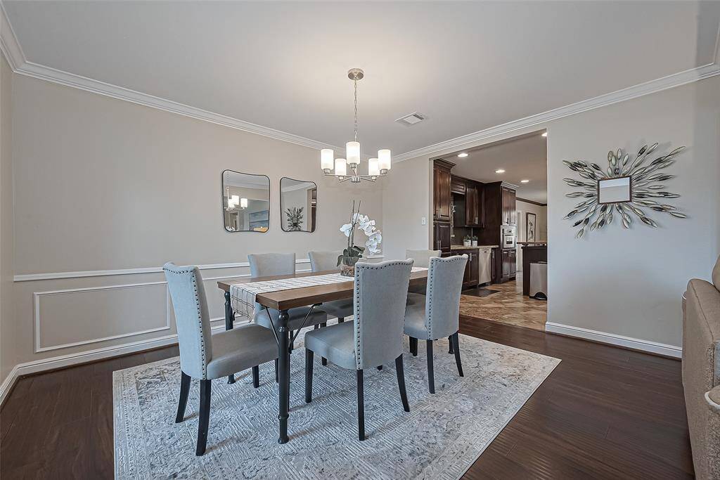 The custom woodwork along the dining room walls adds a refined touch of elegance and character, creating a timeless backdrop for both everyday meals and special gatherings.
