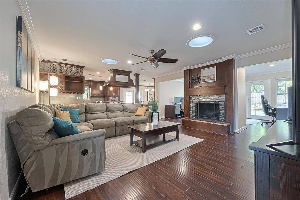 This inviting family features rich hardwood floors, a cozy fireplace framed in stylish tile and woodwork, and an open layout that flows effortlessly into the kitchen—perfect for entertaining or relaxing.
