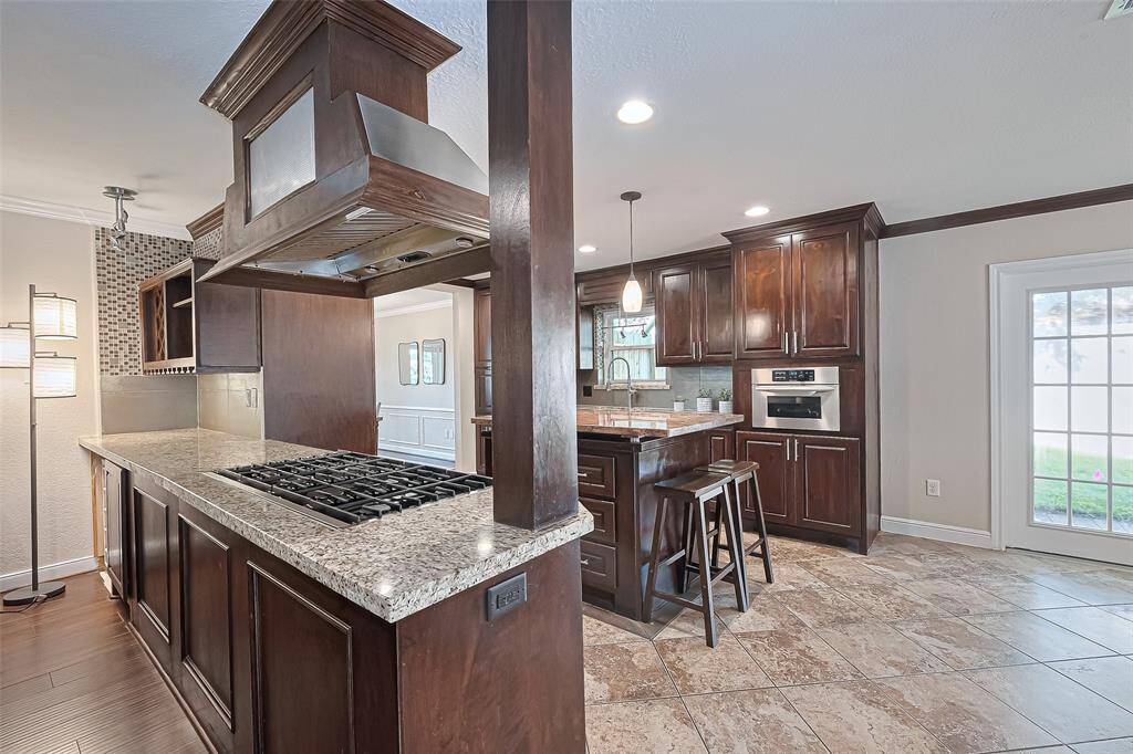 The granite countertops offer both elegance and durability, while the spacious island with bar seating creates the perfect hub for casual meals, conversations, and effortless entertaining.