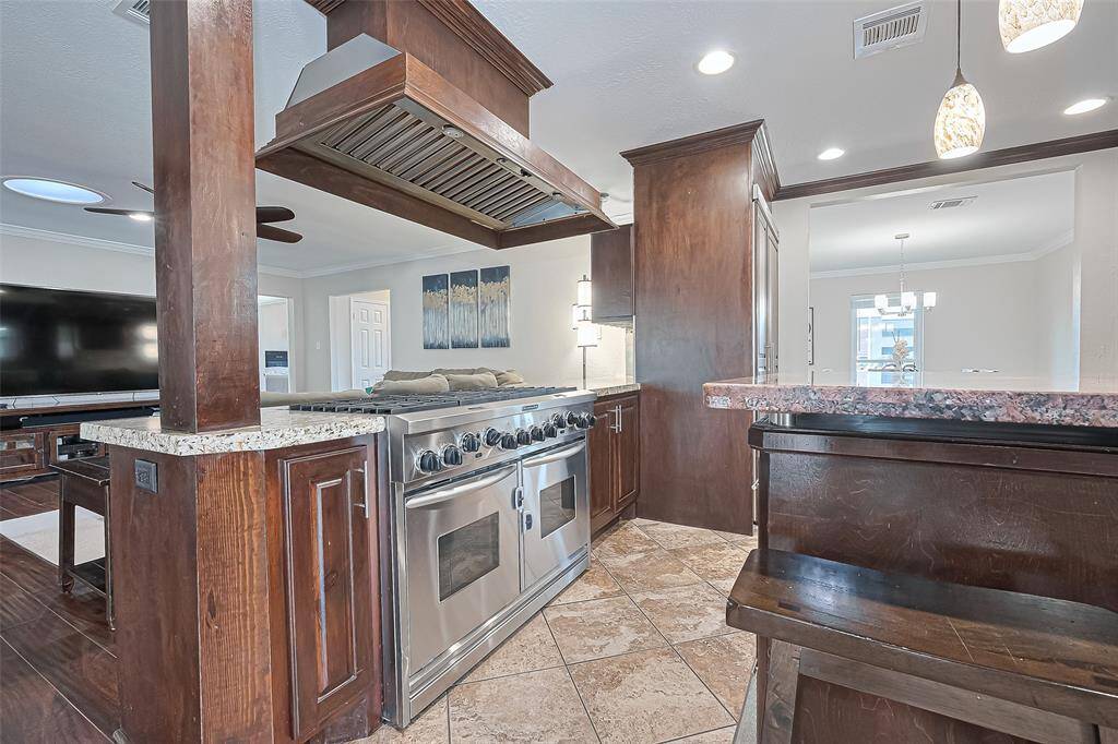 Imagine preparing meals on this professional-grade 8-burner gas range, surrounded by rich wood cabinetry and granite countertops that offer both durability and timeless elegance—this kitchen was truly designed with the passionate home chef in mind.