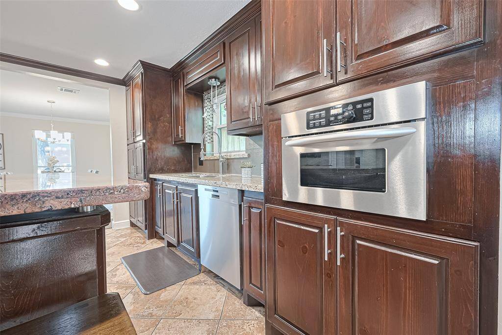 Whether you're rinsing fresh herbs at the deep undermount sink with a stylish pull-down sprayer or reheating leftovers in the built-in stainless steel oven, every detail in this kitchen blends practicality with upscale design to make daily living just a little more delightful.