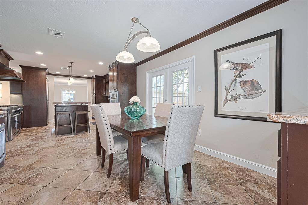 The cheerful breakfast room offers the perfect spot to start your day, featuring French door access to the backyard retreat—ideal for seamless indoor-outdoor living.