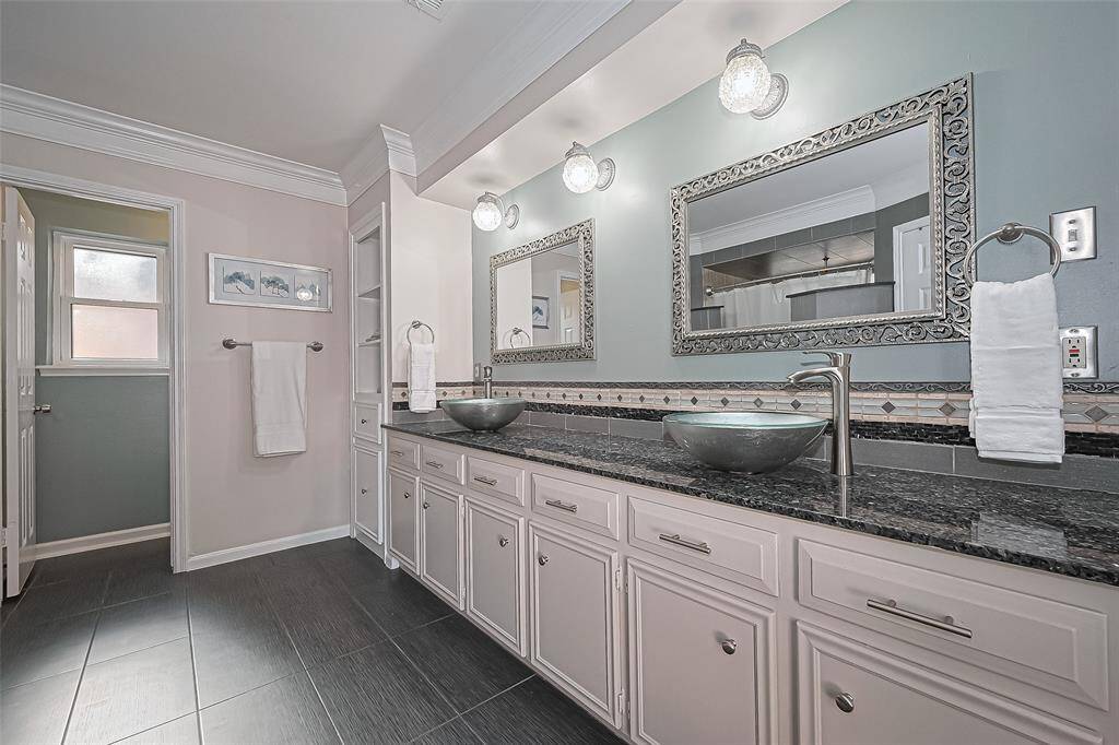 Step into this beautifully appointed primary ensuite bathroom featuring dual vessel sinks, elegantly framed mirrors, and ample countertop space—perfect for shared mornings or a relaxing evening routine.