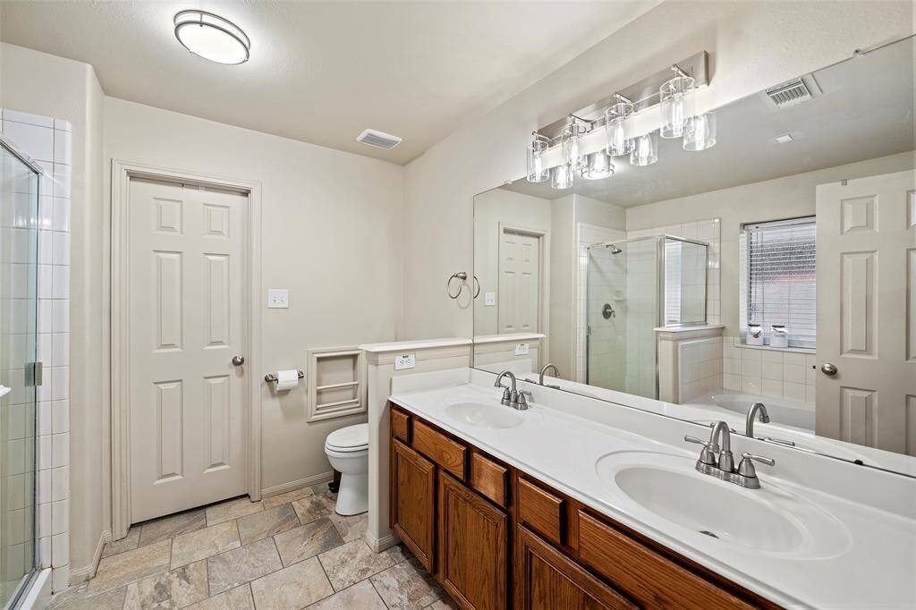 The Primary En Suite has double vanity with plenty of counter space and new light fixtures.