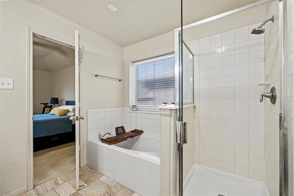 Another view of the primary shows the standup shower and garden tub.