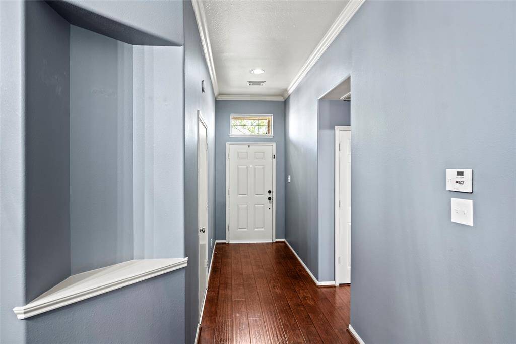 View facing the front door area shows the high ceilings and crown molding in the hallway.