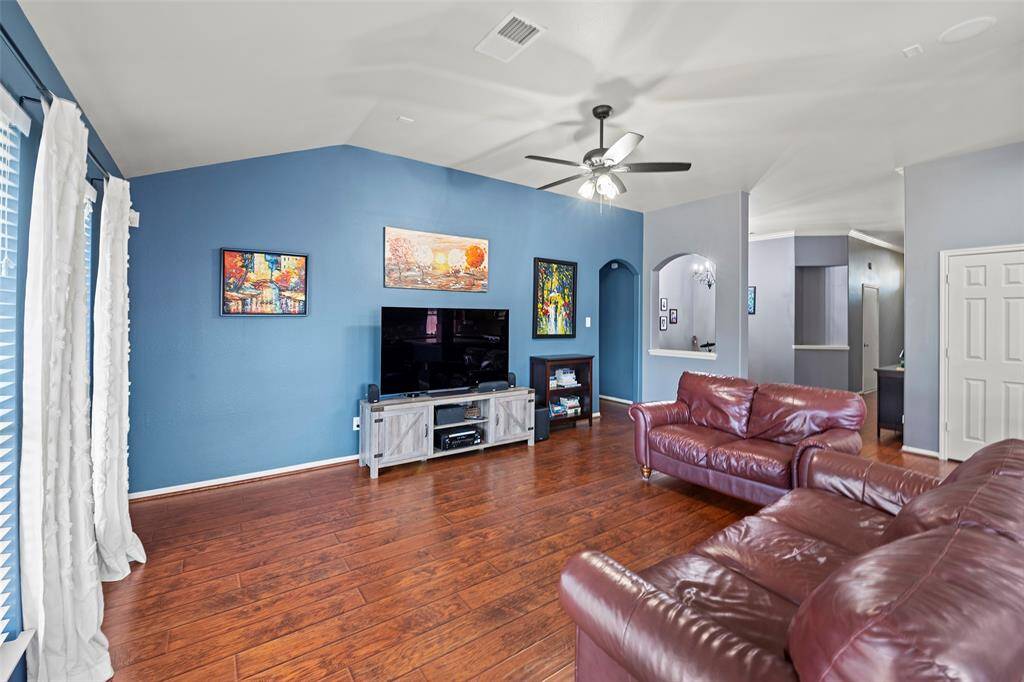 Spacious living area with vaulted ceilings and luxury wood laminate flooring.