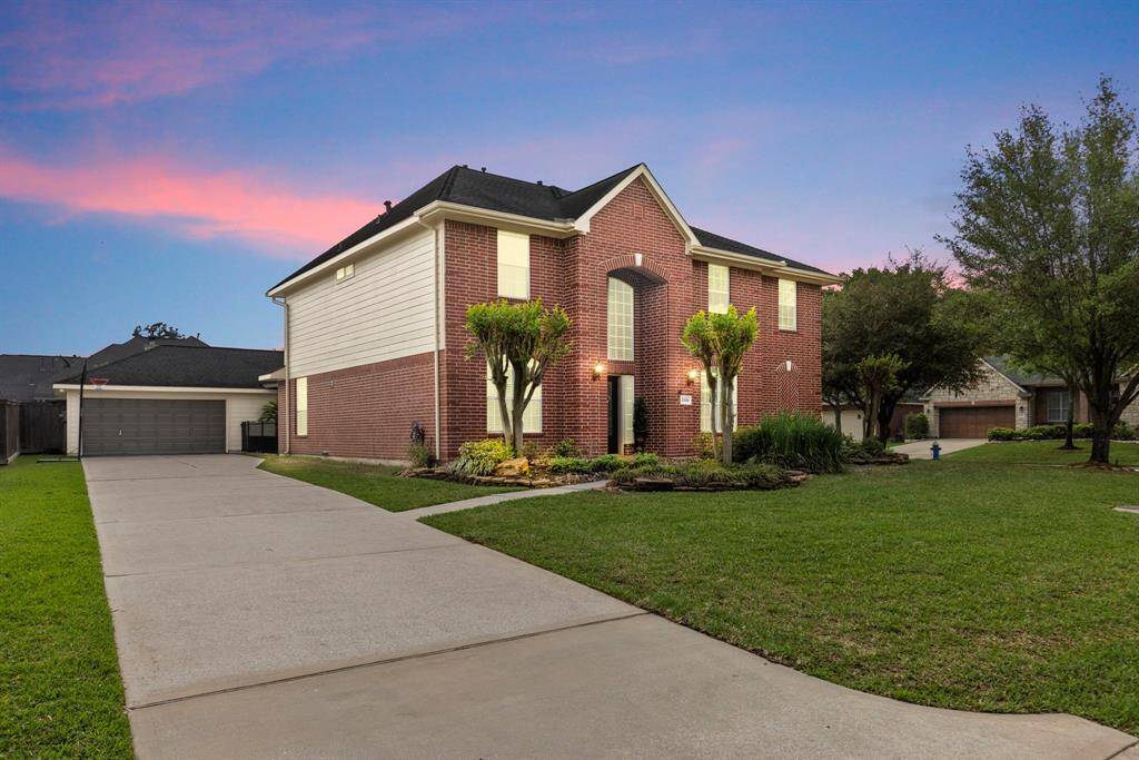 Charming two-story brick home with a spacious driveway and well-maintained lawn. Features a welcoming entrance, mature trees, and a two-car garage. Perfect for family living in a serene neighborhood.