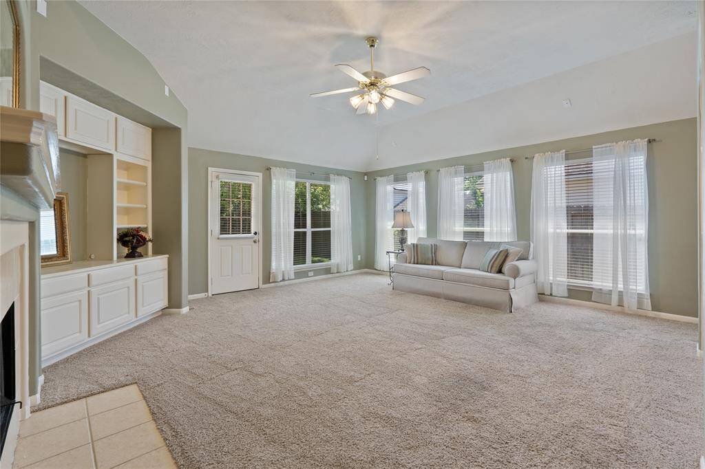The grand living room has an abundance of windows, a built-in entertainment center and a relaxing fireplace.