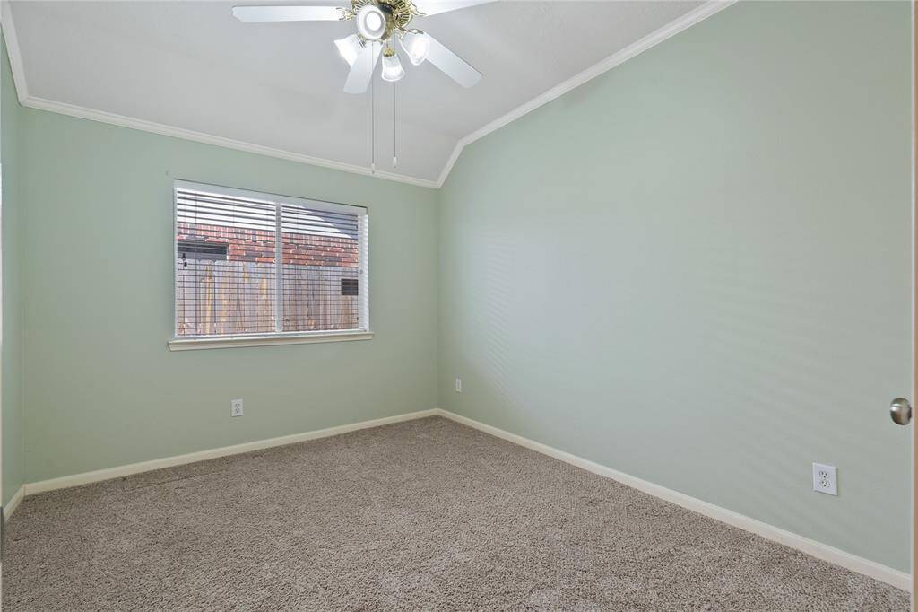 The second secondary bedroom features high ceilings, elegant crown molding, and plenty of space. Makes a perfect guest room.