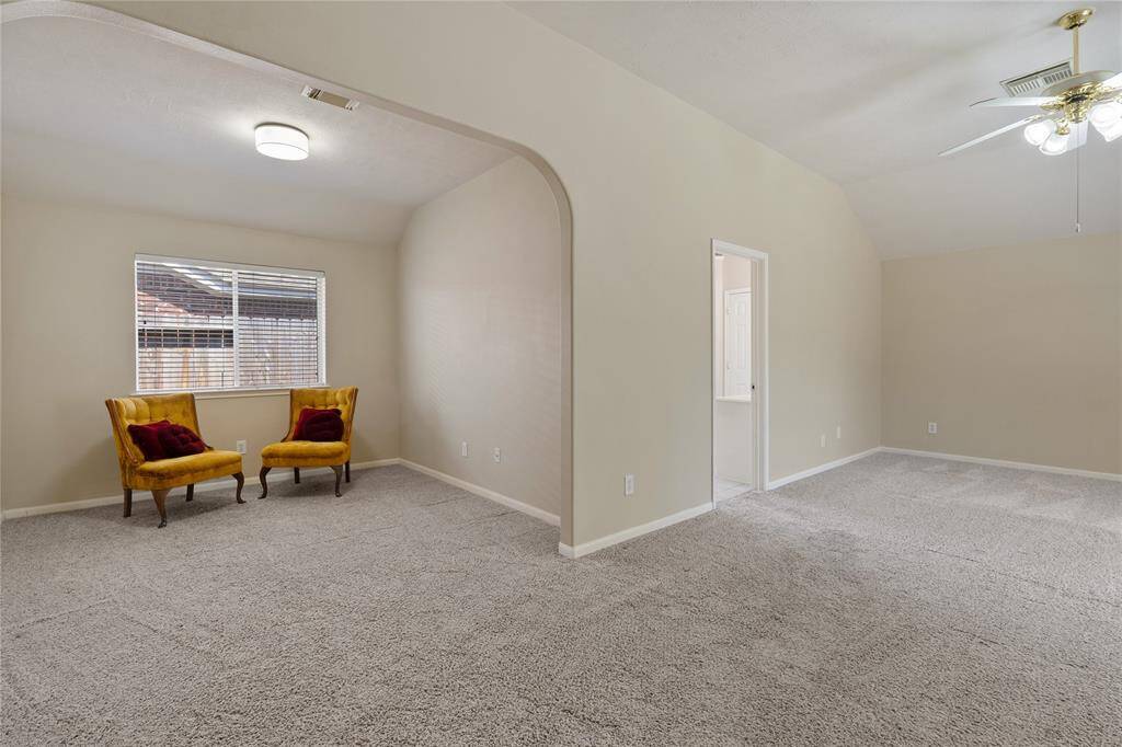 The cozy sitting area located in the primary suite offers versatile use, ideal for a reading nook or a work out space.