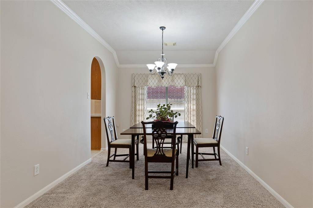 The spacious formal dining room features a large window that fills the space with natural light and a convenient entryway leading into the kitchen.
