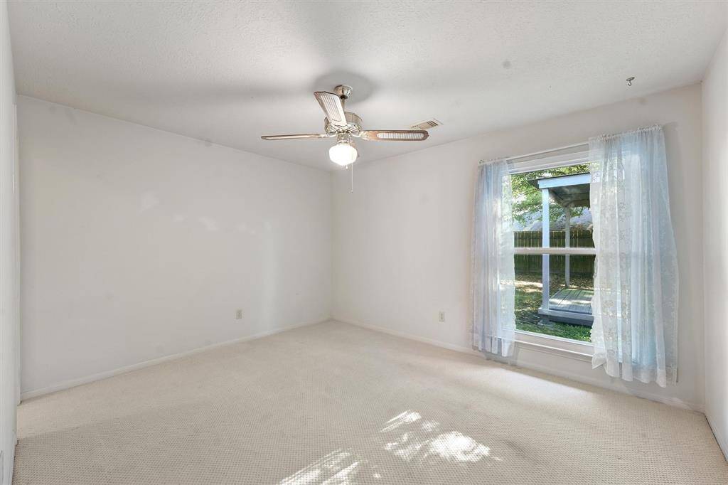 Large, bright bedroom with a large window overlooking the backyard.