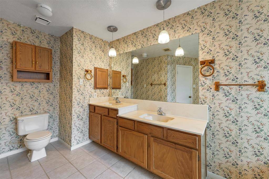 Spacious primary bathroom with convenient storage in the medicine cabinet and above the toilet.
