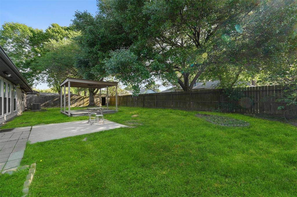 Spacious backyard with multiple patio areas, perfect for outdoor relaxation and entertaining.