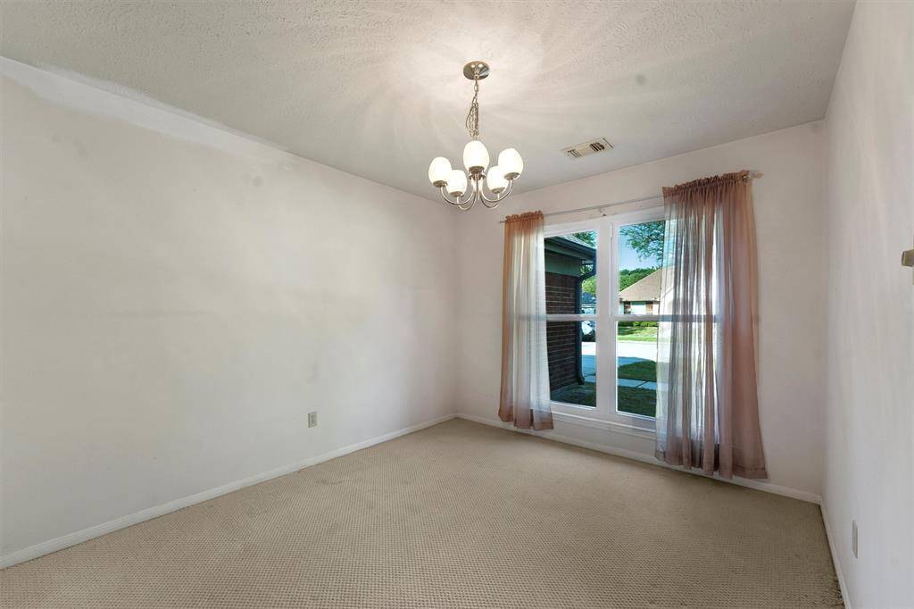 Bright front room featuring a large window allowing natural light. The space is ideal for a dining area, office or sitting room.