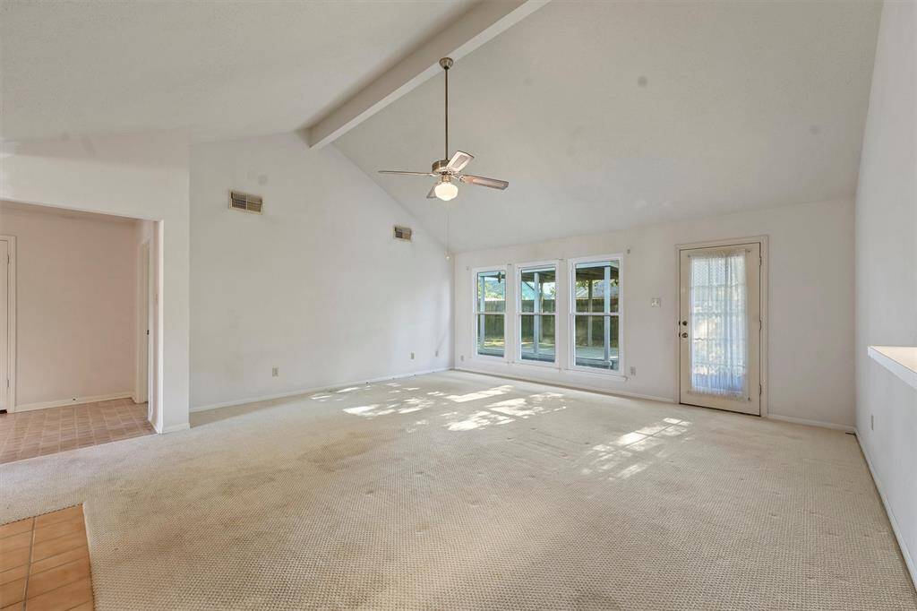 Living room features large windows and a glass door leading outside, offering plenty of natural light.