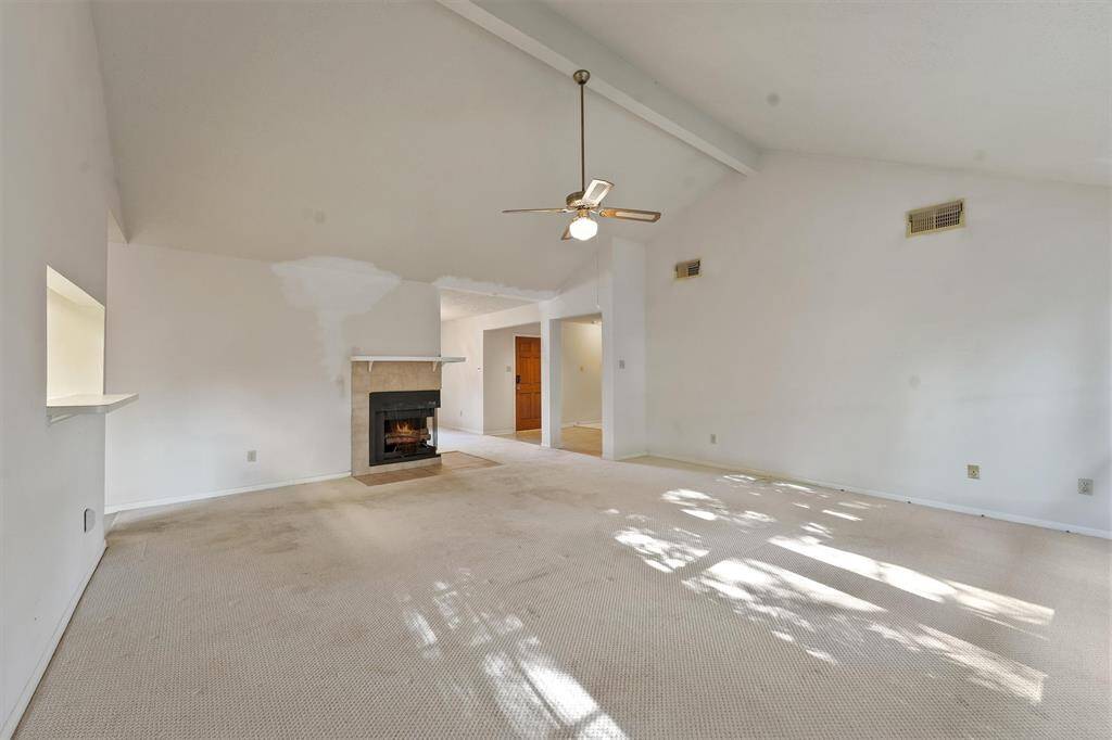 Spacious living room features a cozy fireplace and a view of the entryway.