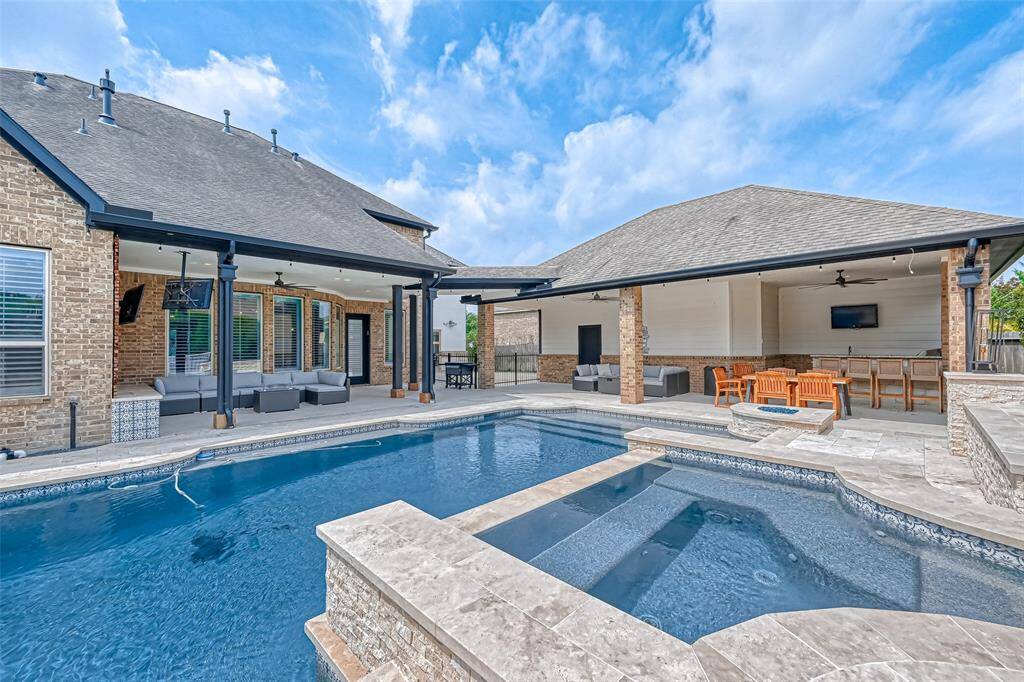 View of pool, hot tub and outdoor living spaces.