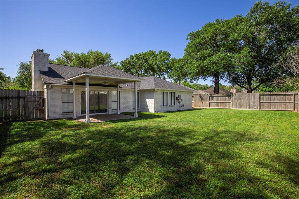Covered patio leads to an open and manicured back yard