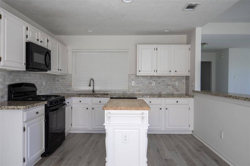 Granite counters and excellent color combination with new tile floors, backsplash and cabinets